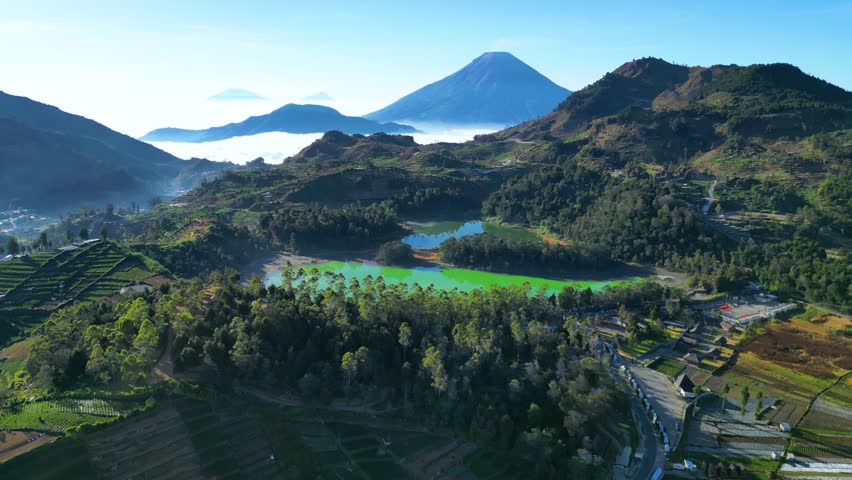 Established Aerial View of Telaga Warna (Lake Telaga Warna), Telaga Pengilon (Lake Pengilon) in the Dieng Plateau, Central Java. Indonesia. You can also see Mount Sindoro in the Background Royalty-Free Stock Footage #3389943009
