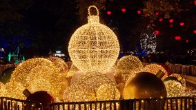 Large outdoor Christmas ball ornament decorations display illuminated at nighttime at a Christmas Village - Powered by Shutterstock - Get 15% off with code: PIKWIZARD15