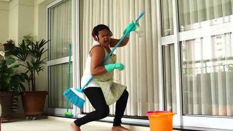 Funny Housekeeper Dancing and Having Fun With Broom