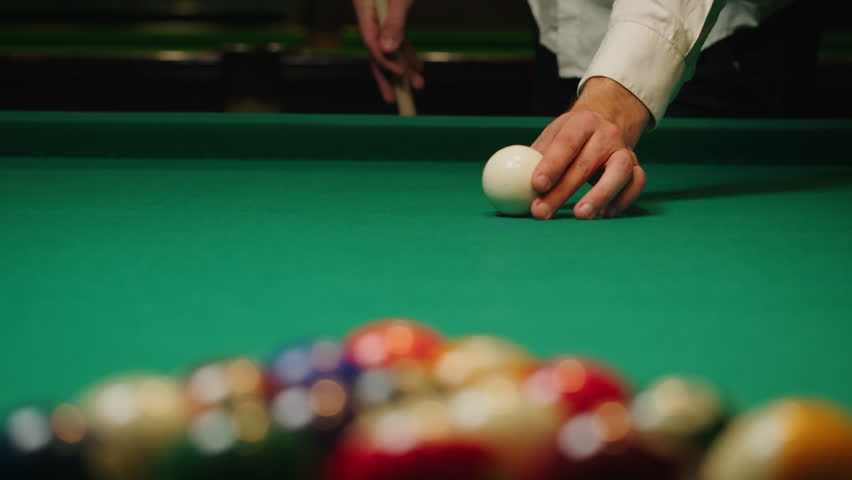 Young man breaking colorful pool balls with cue on green billiards table for start to play. American pool, poule game. Billiard balls with numbers on a pool table. Billiards team sport. | Shutterstock HD Video #3390698023