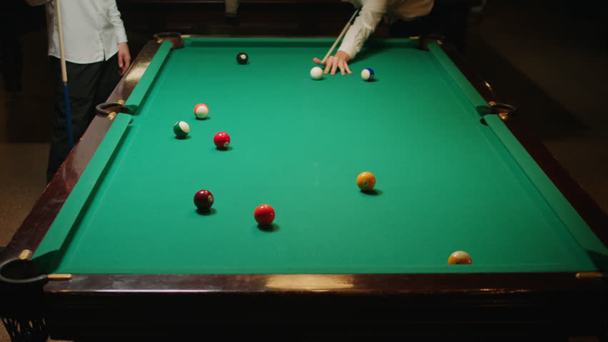 Young men playing American billiard poule close-up. Colorful balls on green billiards table .Billiard balls with numbers on a pool table. Billiards team sport. | Shutterstock HD Video #3390701585