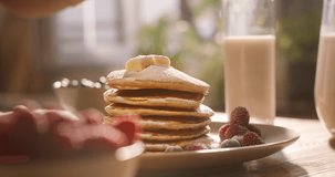 Unknown cook carefully decorates perfect stack pancakes with sprig of mint herb. Advertising cinematic. Healthy lifestyle with gluten-free food options, nourishing with delicious and nutritious meals
