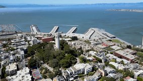 Drone footage of Coit Tower overlooking the urban grid of San Francisco. Ideal for travel and historical content.