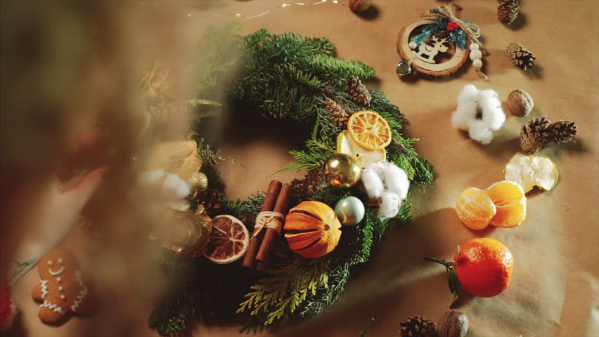 top view Christmas wreath on craft background, pretty famale hand decorate christmas wreath, motion shot