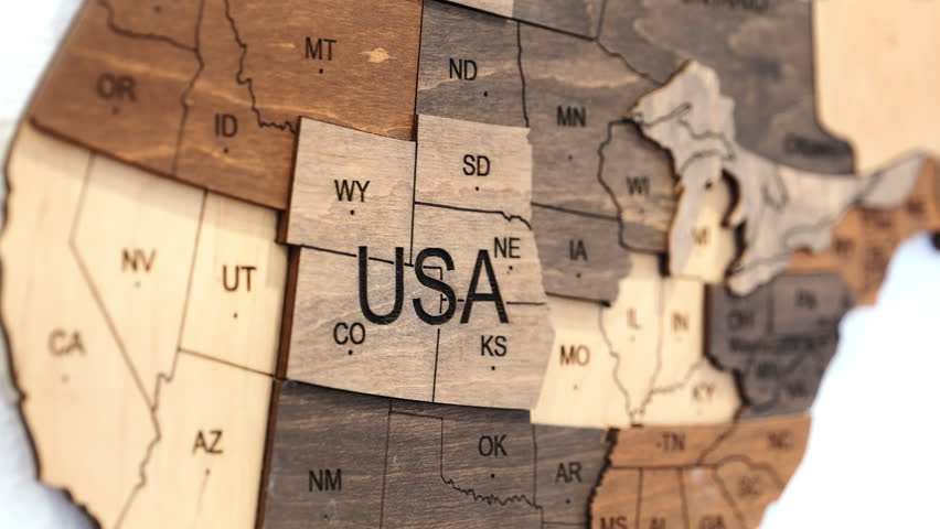 Close-up video of a wooden USA map focusing on the central states, then zooming out to reveal the entire country, showcasing the geography and state borders.