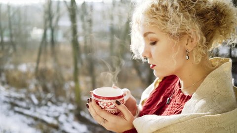 cinemagraph, cold sunny morning,closeup portrait pretty girl with cup of tea  on balcony, , Looping Motion Photo.