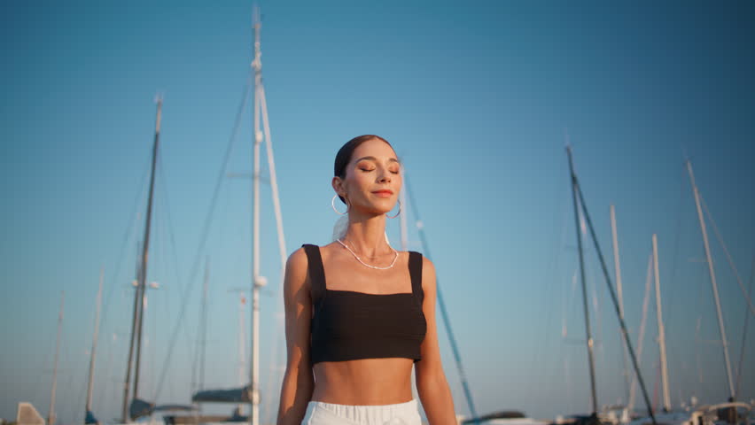 Fashion woman feet walking sunny port with moored luxury yachts. Elegant rich lady enjoy relaxed stroll at beautiful embankment alone. Gorgeous carefree brunette going on date at summer waterfront.