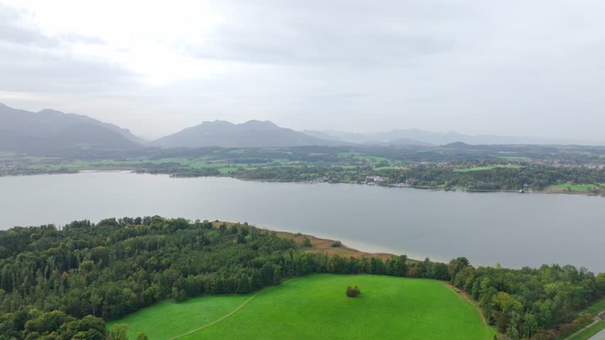 Chiemsee, Bavaria, Germany - A Freshwater Lake Encircled by Vibrant Green Landscapes, Framed Against a Backdrop of Majestic Mountains - Aerial Pan Right