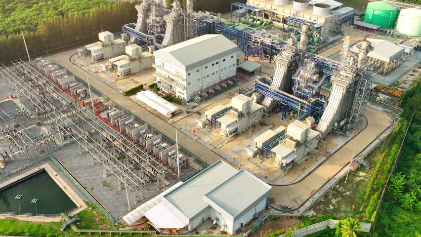 A Combined-Cycle Power Plant generates electricity by burning natural gas and reusing waste heat, making it both environmentally friendly and economically viable. Bird's eye view by drone.
 Royalty-Free Stock Footage #3390864767