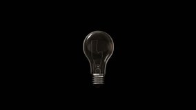 Switching on, turning off light bulb animation. Warm yellow light over dark black background. Bright glowing and flickering Edison Tungsten lamp. Retro vintage form. Creative idea concept. 3D 4K clip