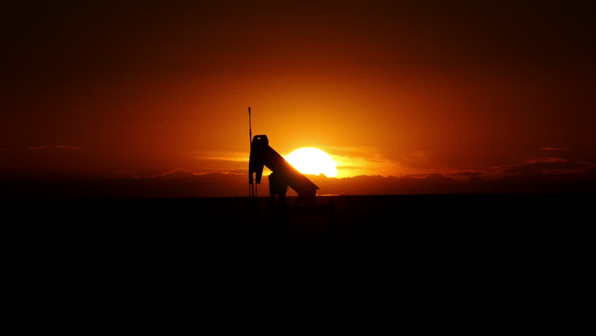 Pump jack in operation at a Texas oil well at sunset