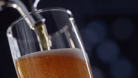 Pouring cold craft light beer with bubbles into glass detail shot macro super slow motion video.
