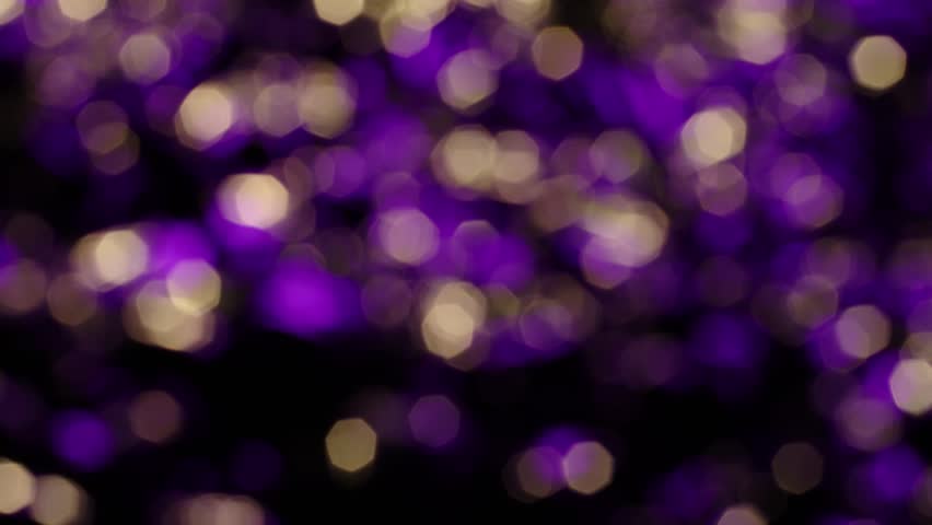 Purple and gold lights color fall on a dark black background in an abstract order, beautiful reflection of glare from the light, bokeh and out of focus glare. Slow motion, 8K downscale, 4K. Royalty-Free Stock Footage #3391133469