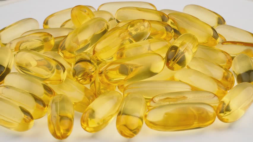 Close-up: dietary supplements in capsules. Pharmaceuticals vitamins and minerals in convenient capsules spin on the platform. Medicines omega 3, omega 6, omega 9 in capsules.