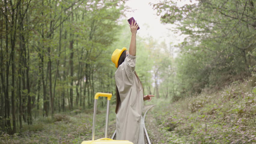 Technology support: In a remote location, a young woman is looking for a mobile connection to call and contact her family. Traveler, tourist in search of internet and satellite signal | Shutterstock HD Video #3391274895