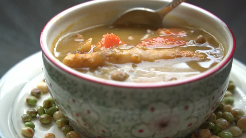 Dipping dumplings inside soup bowl Preparing jamaican gungo pea soup after being picked from tree healthy green fresh protein cultivation harvested