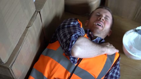 Injury at work. A male warehouse worker man is injured and in pain. For injury compensation claim. 4K.
