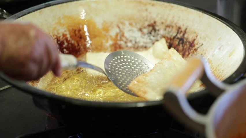 Typical Brazilian food pastel being fried inside boiling pan with oil