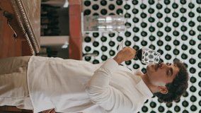 Professional young man winemaker sip red wine from glass goblet tasting flavour gourmet drink vertical view. Italian sommelier drinking grape beverage at degustation in cozy cellar. Winemaking concept - Powered by Shutterstock - Get 15% off with code: PIKWIZARD15