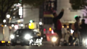 SHIBUYA, TOKYO, JAPAN : View of street traffic at night. Many cars, bus, taxi and bike passing by on the road. Japanese transportation and traffic concept video. Out focus shot.