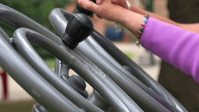 Senior people exercising at the outdoor gym with the help of a caregiver. High quality 4k video.