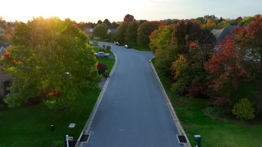 American neighborhood during golden hour on autumn evening. Aerial shot of houses and homes.