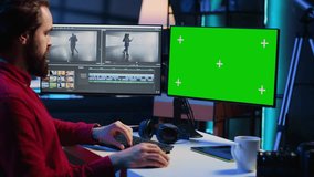 Video editor trimming segments of drone shot footage, using green screen PC monitor to work. Videographer splicing film pieces, editing them using professional software on mockup computer display