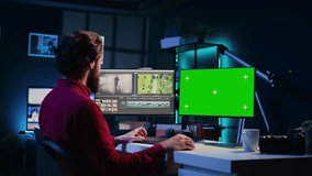 Video editor using editing software on green screen monitor to upgrade footage shot, commissioned by production teams outsourcing tasks. Freelancer videographer finishing project on mockup PC