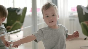 Cute baby playing at home. A small child looks at himself in the mirror and points his finger at his reflection. Toddler boy examines furniture and objects in his room - Powered by Shutterstock - Get 15% off with code: PIKWIZARD15