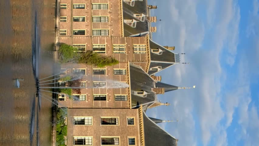 View of the Binnenhof House of Parliament and the Hofvijver lake with downtown skyscrapers in background. The Hague, Netherlands. Camera pan