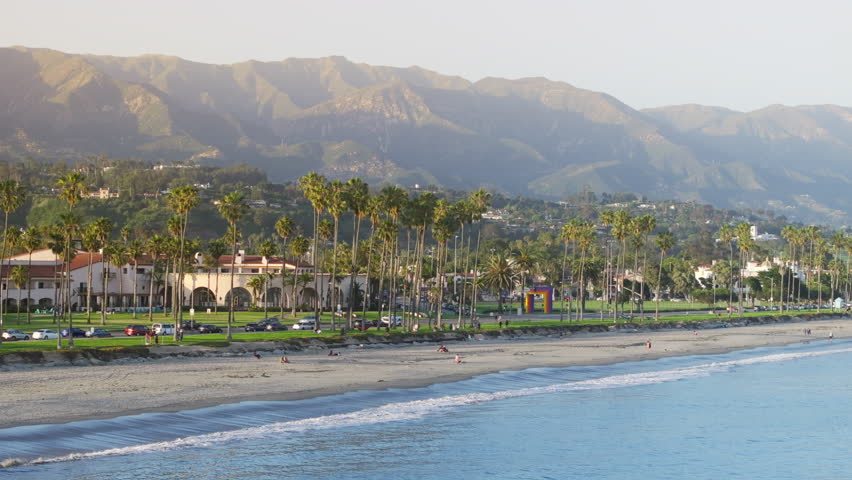 Overview of coastal landscape of Santa Barbara resort city, California, USA. Drone shot of tropical beach with palm trees. Pacific Ocean waves rolling on the shore. City skyline surrounded mountains  Royalty-Free Stock Footage #3391607705
