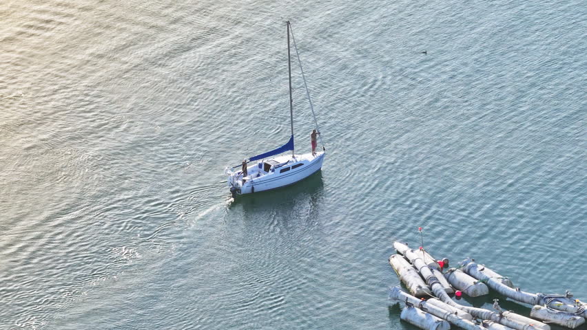 Aerial view of men floating on sailboat Santa Barbara Harbor at the sunset, California, USA. Overhead shot of luxury yacht with people on the board driving in Pacific Ocean. Travel concept, 4k footage Royalty-Free Stock Footage #3391609515