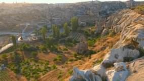 A captivating aerial stock video of the Cappadocia region in Turkey. Valleys with houses gracefully carved into the rocks unfold below, revealing its extraordinary charm. The unique rock formations
