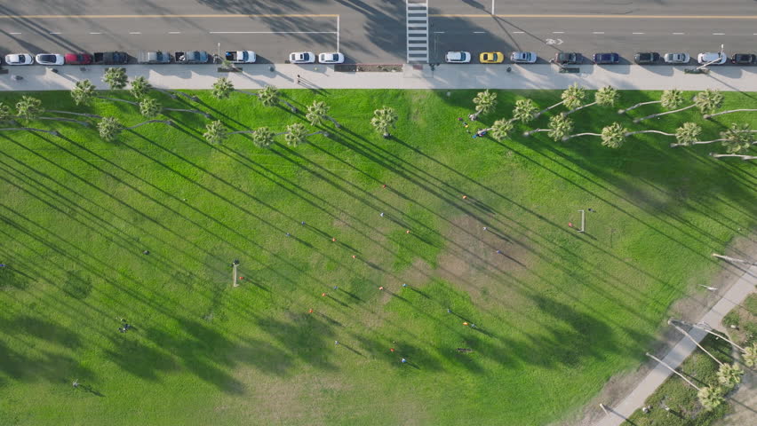 Top shot of active men training outdoors with soccer ball, Santa Barbara, California, USA. Drone view of soccer players exercising on green field together. Summer outdoor activities, 4k footage  Royalty-Free Stock Footage #3391616639