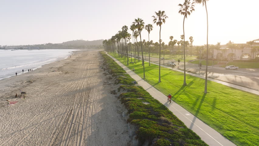 Drone flying over people enjoying time on the beach of Santa Barbara at sunset, California, USA. Aerial view of resort city along Pacific Ocean. City life at summer. Vacation concept, 4k footage  Royalty-Free Stock Footage #3391622479