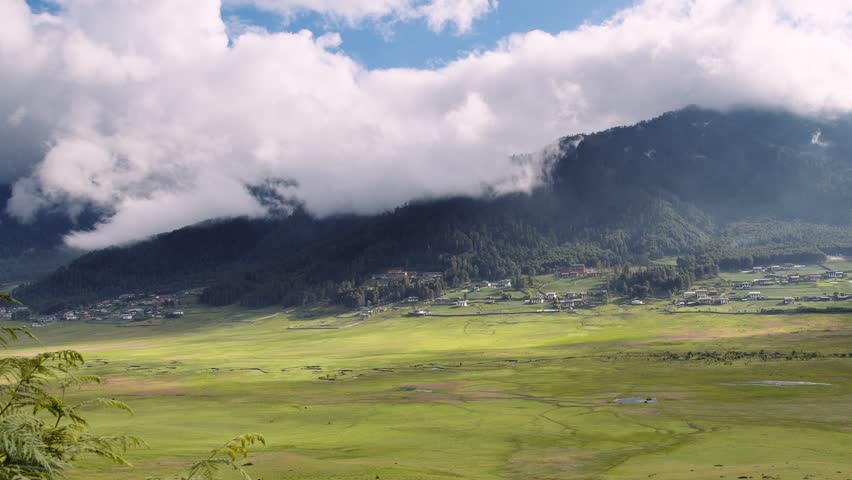 View of scenic landscape with mountains and clouds in Bhutan, view of the meadows in Phobjikha valley in Bhutan.