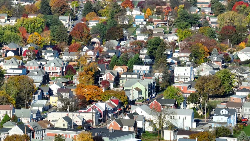 Residential suburb with colorful autumn trees. Aerial shot of neighborhood in American town.