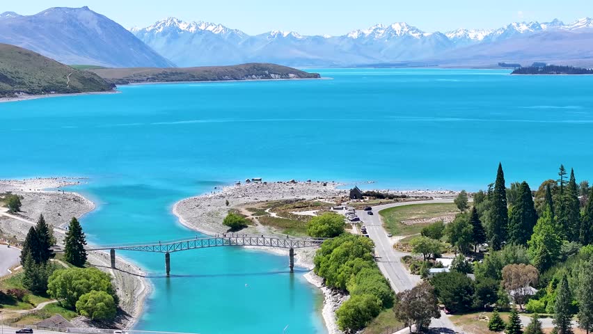 Breathtaking beauty of nature. Lake Tekapo in New Zealand surrounded by mountains, bridge and church.