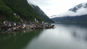 Mystic Rainy Day in Hallstatt, Austria; Drone View of Evangelische Pfarrkirche Lutheran Church Amidst Austrian Architecture and Majestic Mountains. Enchanting Atmosphere for Travel and History Videos