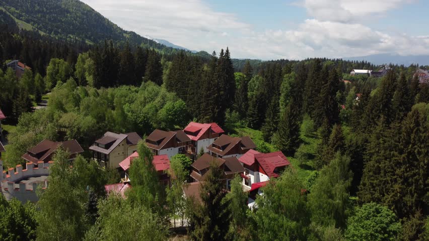 Dracula's Domain from Above: Aerial 4K Drone Shot Showcasing 'House of Dracula' at Poiana Brasov Ski Resort in Carpathian mountains; Stunning Views of Bran Castle and Transylvanian Scenery Royalty-Free Stock Footage #3391656543