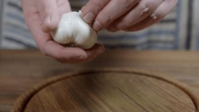 Peeling process of head of garlic by chef who is preparing chimichurri sauce