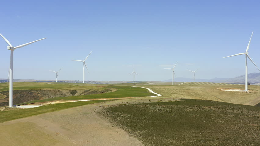 Drone of windmill blue sky and field for renewable energy, sustainability or eco friendly power plant. Aerial view of wind turbine, green electricity and farming with carbon footprint in South Africa