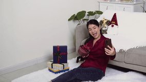 Asian woman happy shows gift box on video call.