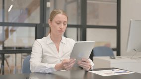 Mature Business Woman Doing Video Chat on Tablet in Office