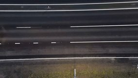 Top view of the asphalt road, passing cars illuminate the markings with their head lights. Quiet Morning on a Newly Constructed Highway with Nature Views - Powered by Shutterstock - Get 15% off with code: PIKWIZARD15