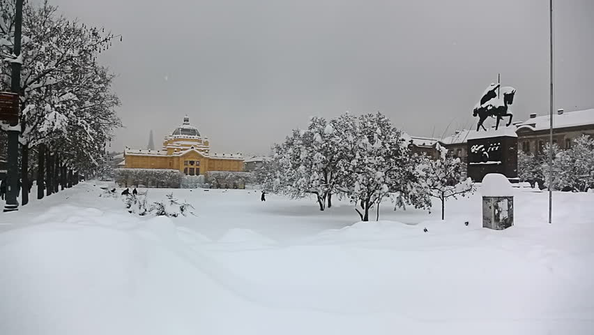 Panorama of king Tomislav square with statue and art gallery pavilion in back while heavy snowing, Zagreb, Croatia.