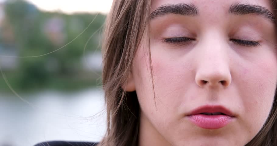video expression Resentment on face sharpen the lower lip upset be sad face of young girl close-up shows dissatisfaction playfulness coquetry raise eyes to upper right corner wind blows hair Royalty-Free Stock Footage #3391979235
