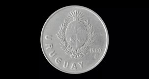Obverse of Uruguay coin 1 peso 1980, isolated in black background. Loopable animation in 4k resolution video.
