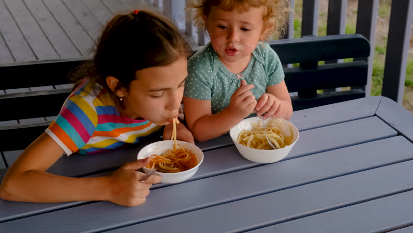 child eats pasta. Selective focus.