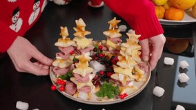 Homemade star-shaped cookies made from puff pastry, herringbone canapés with ham and cheese. Beautiful presentation on a plate on a black background. The girl's hands rotate a plate with a snack. Clos - Powered by Shutterstock - Get 15% off with code: PIKWIZARD15